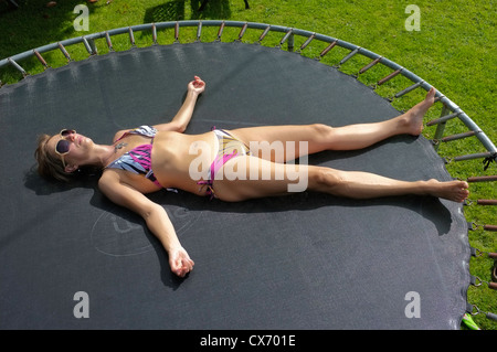 Woman sunbathing trampoline bikini hi res stock photography and