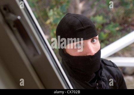 Burglar looking through house window Stock Photo