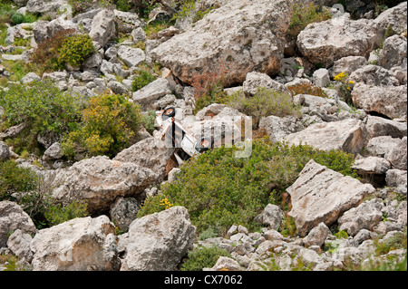 Wrecked car on rocks Stock Photo