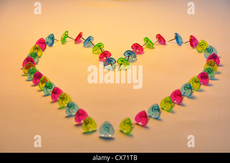 Heart of Hearts - Heart symbol made of coloured plastic heart shaped pins. Stock Photo