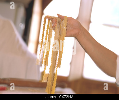 Still Fattoria La Vialla: Female hand holding fresh pasta Stock Photo