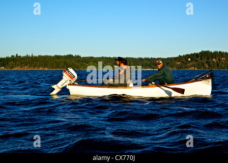 Two anglers trying to catch big chinook salmon in Tyee Pool at mouth of Campbell River with guide rowing traditional rowboat Stock Photo