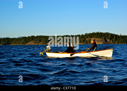 Two anglers trying to catch big chinook salmon in Tyee Pool at mouth of Campbell River with guide rowing traditional rowboat Stock Photo