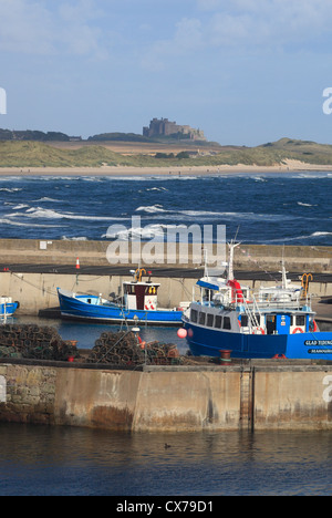 The harbour at Seahouses on the Northumberland coast with Bamburgh Castle in the background. Stock Photo