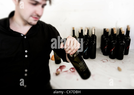 Portrait of young man drinking a bottle of wine Stock Photo