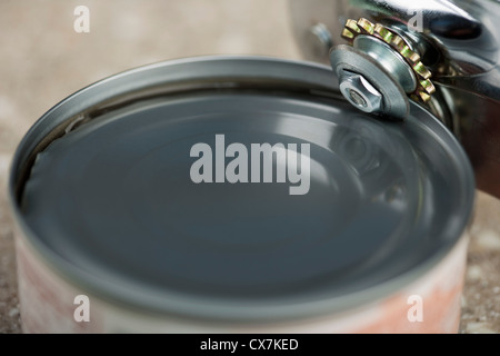 Tin opener opening canned food Stock Photo