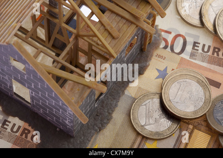 A partially constructed miniature model of a house standing on top of European Union currency Stock Photo