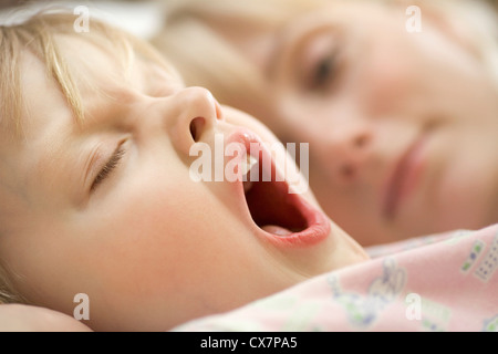 A young girl and her mother waking up in the morning Stock Photo