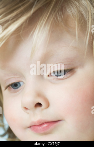 A cute little girl looking down, extreme close-up Stock Photo