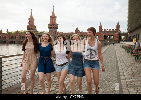 Five female friends walking side by side near the Oberbaumbruecke, Berlin, Germany Stock Photo
