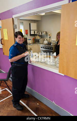 A British police community support officer (PCSO) having a tea break at a local church fundraising fete. Stock Photo