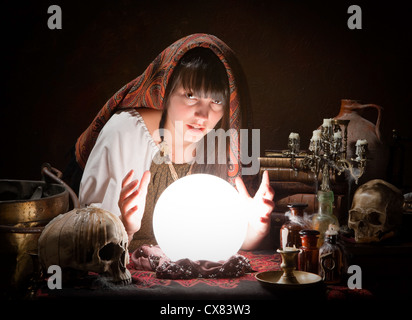 Young fortune-teller reading the future in a crystral ball Stock Photo