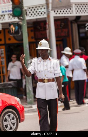 A member of the Royal Bahamas Police wearing a Wolseley pith helmet directs traffic in Nassau, Bahamas. Stock Photo