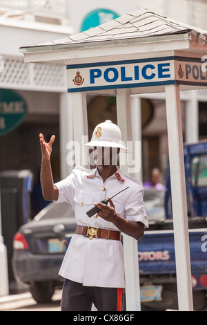 A member of the Royal Bahamas Police wearing a Wolseley pith helmet directs traffic in Nassau, Bahamas. Stock Photo