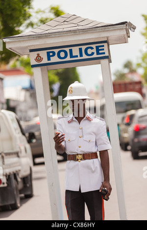 A member of the Royal Bahamas Police wearing a Wolseley pith helmet directs traffic in Nassau, Bahamas. Stock Photo