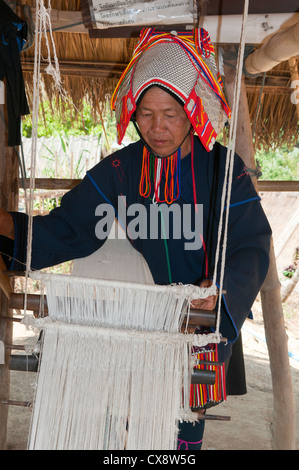 Akha woman weaving on her loom, Chiang Rai, Thailand Stock Photo