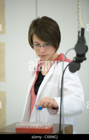 Young woman preparing solutions in laboratory Stock Photo