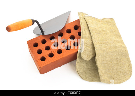 Red perforated ceramic brick, trowel and gauntlet isolated on white Stock Photo