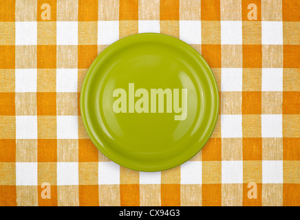 green plate on yellow checked tablecloth Stock Photo