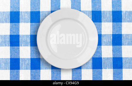 white plate on blue checked fabric tablecloth Stock Photo