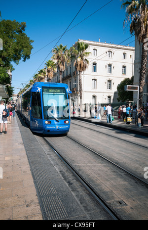 Modern tram travelling down Rue De Maguelone in Montpellier operated by the Transports de l'agglomération de Montpellier TAM. Stock Photo