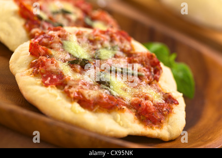 Crispy homemade Pizza Margherita or Pizza Mozzarella (pizza with tomato, basil and cheese) on wooden plate Stock Photo