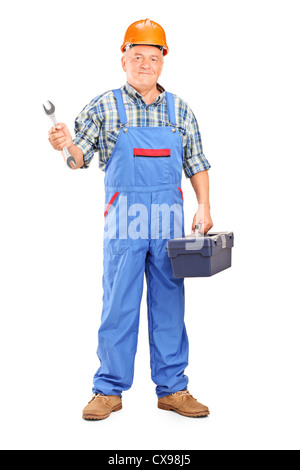 Mature mechanic holding a box of tools and a wrench Stock Photo