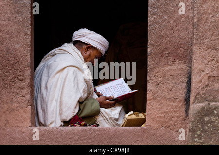 Priest reading the bible in Bet Giyorgis Church Lalibela Ethiopia. Stock Photo