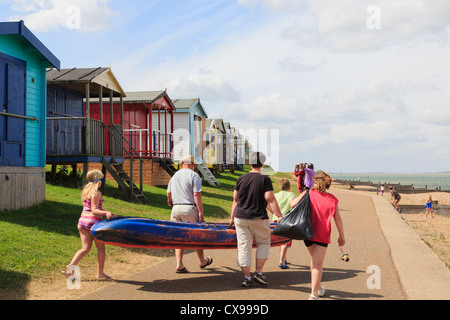 People on Whitstable seafront promenade with beach huts on north Kent coast Thames estuary in summer. Tankerton Whitstable Kent England UK Britain Stock Photo