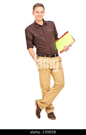 Young man holding books and leaning against wall Stock Photo