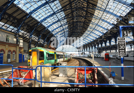 Brighton, United Kingdom - Brighton steel and glass railway station and train in the Spring sunshine. Stock Photo