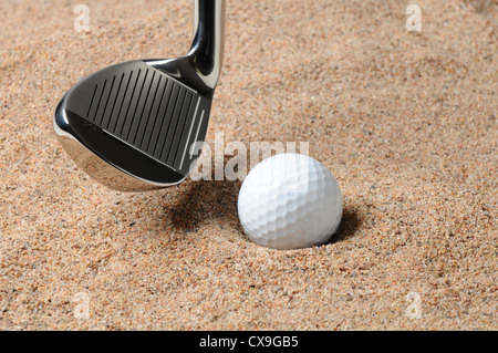 Golf Ball in Trap with Sand Wedge about to strike the Golfball. Close up in horizontal composition with copy space. Stock Photo