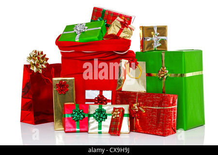 A red Christmas sack full of and surrounded by gift wrapped presents, isolated on a white background. Stock Photo