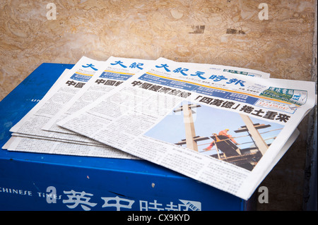 London West End Chinatown The Epoch Times Chinese language edition pile free newspapers news papers stand Stock Photo