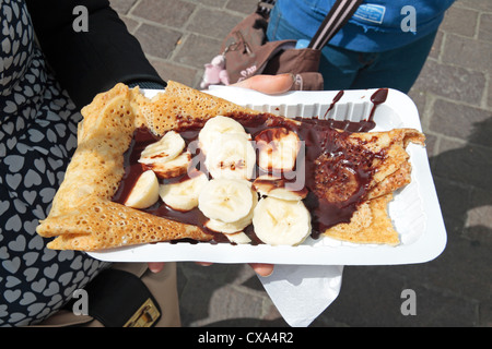 Banana pancakes and chocolate sauce on a paper plate/ tray (purchased in Ieper (Ypres), Belgium. Stock Photo