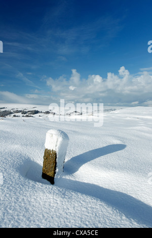 Winter view of snow covered moors, looking west from Castleton Rigg with a parish boundary stone in the foreground Stock Photo