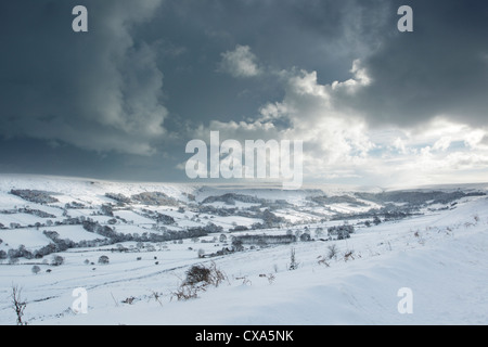 Winter view of a gathering storm over snow covered moors, looking into Danby Dale in the North York Moors National Park. Stock Photo