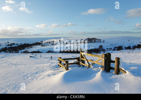 Winter view of snow covered moors, looking over a wooden gate Stock Photo