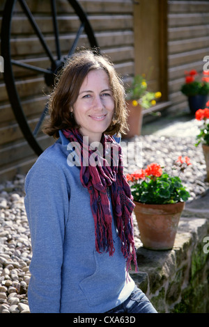 Happy young woman sitting on a wall Stock Photo