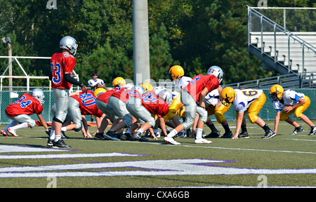Teams of 7th grade boys on the line ready for the quarterback to snap the ball. Stock Photo
