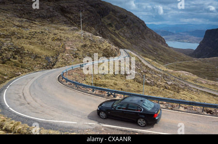 A car descending the twisty road that leads down Bealach na Ba, Scottish Highlands. Stock Photo