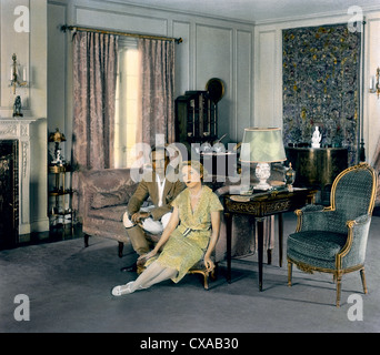 Colorized portrait of American actor, screenwriter, director, and producer Douglas Fairbanks (1883 – 1939) and his wife, Canadian born American actress and producer Mary Pickford (1892 – 1979) sitting next to the fireplace in the living room of their 18-acre estate, Pickfair, Beverly Hills, California, 1931. (Photo by Burton Holmes) Stock Photo