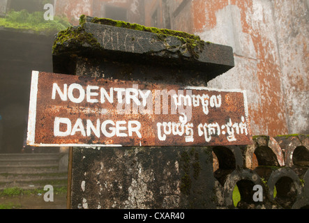 warning sign on the ruins of the old French casino and resort on Bokor Mountain near Kampot, Cambodia Stock Photo