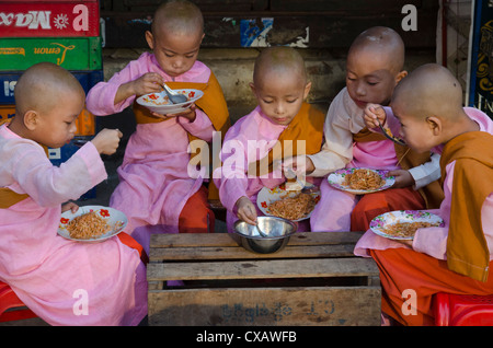 Young novice nuns having their breakfast in the streets of Yangon, Myanmar (Burma), Asia Stock Photo