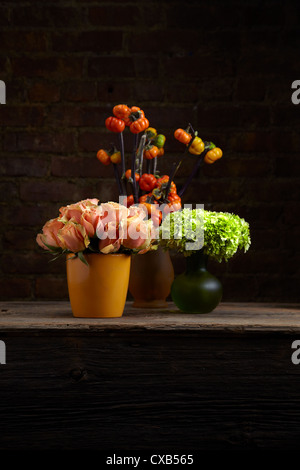 A trio of Tangelic Rose, Hydrangea and Stick Pumpkin Flower Arrangements Stock Photo