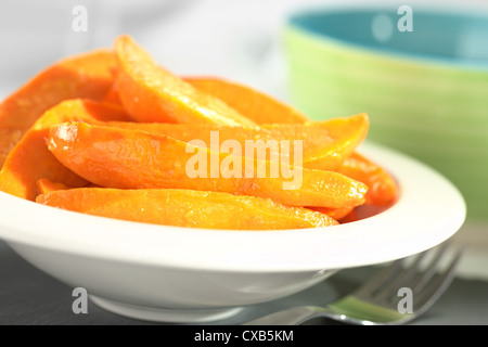 Fresh homemade caramelized sweet potato wedges in white bowl (Selective Focus, Focus one third into the sweet potatoes) Stock Photo