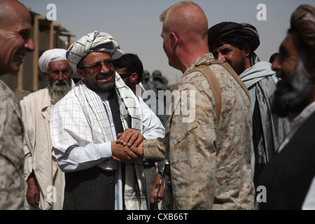 Colonel Duffy White greets Provincial Governor Gulab Mangal after his arrival July 14, 2009 at Forward Operating Base Delhi, Helmand Province, Afghanistan. The governor sat in on a brief about the Marines' activities during Operation Khanjar, a ribbon cutting at a new irrigation sluice gate and a shura in Garmsir where he unveiled his new District Development Plan to more than 400 local elders and residents. Stock Photo