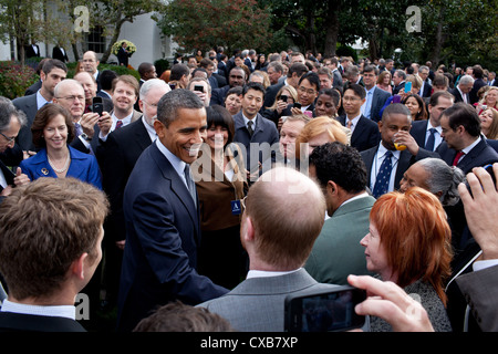 US President Barack Obama drops by a reception celebrating the signing of the Trade Adjustment Assistance Extension Act and the Korea, Panama and Colombia Free Trade Agreements October 21, 2011 in the Rose Garden of the White House. Stock Photo