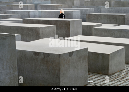 A female tourist walking through the Holocaust Memorial in Berlin, Germany Stock Photo