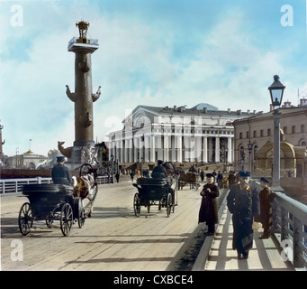 Colorized photo of horse-drawn carriages and soldiers on a bridge leading to Vasilyevsky Island, St. Petersburg, Russia, 1901. One of the Rostral Columns is to the left and the Stock Exchange Building is in the center of the image. (Photo by Burton Holmes) Stock Photo